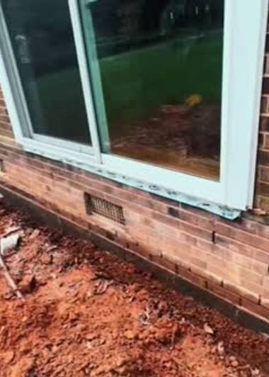 Wet soil along a crawl space foundation wall